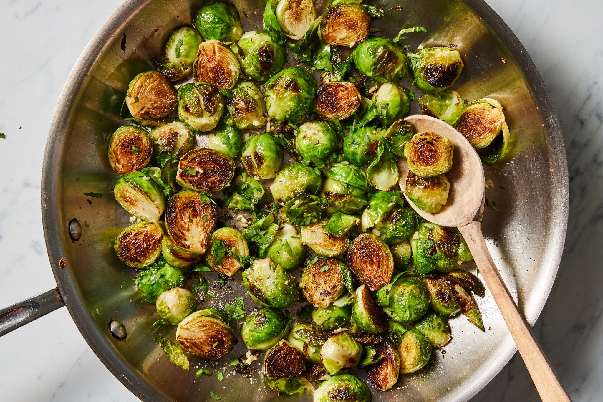 An overhead image of halved brussels sprouts in a skillet, their insides a beautiful golden brown.