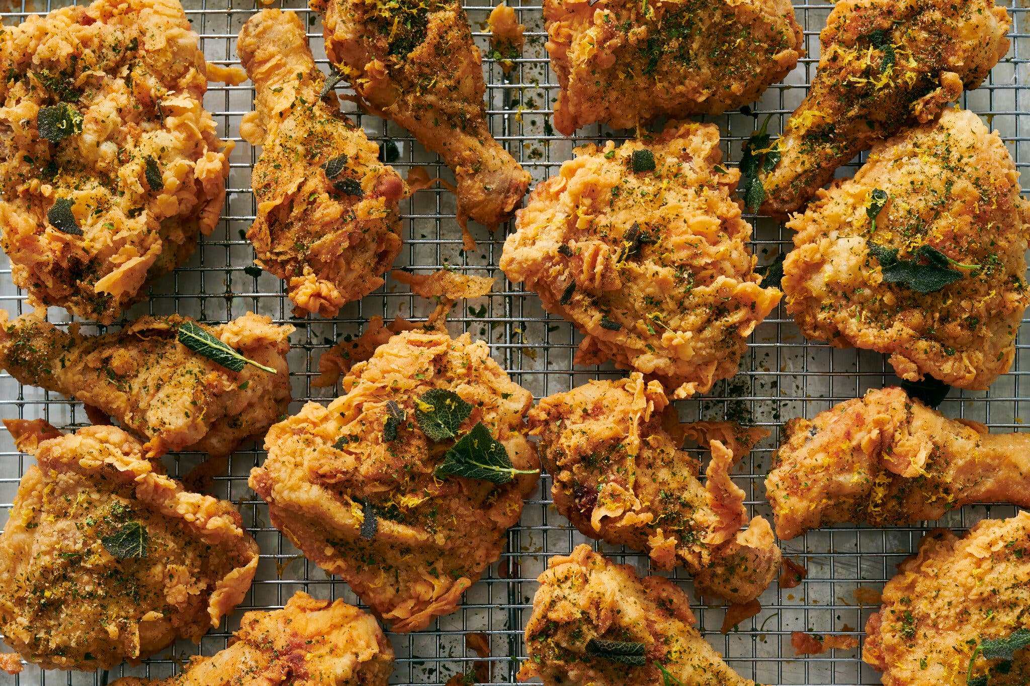 An overhead image of craggly fried chicken topped with crisp sage.